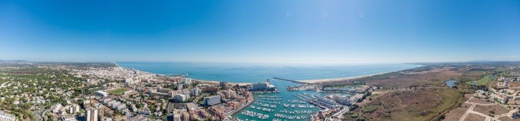 Sensational panorama of beautiful Vilamoura city. Luxury hotels, yachts docked in the port. Famous travel destination in south of Portugal - Algarve region. View of the city and the port area