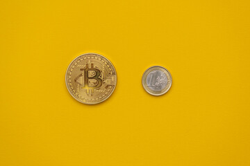 Bitcoin BTC physical golden coin and 1 euro coin equated. Crypto currency and fiat money concept. Cool minimal flat lay, copy space - obrazy, fototapety, plakaty