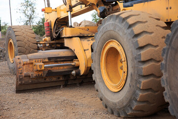 The process of repairing or building a road with a motor grader. The blade of the motor grader is a part of the machine.