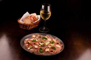 romantic dinner with carpaccio cold meats basket of artisan breads caper mustard dijon glass of white wine