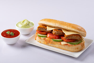 Fresh submarine sandwiches with ham, cheese, bacon, tomatoes, lettuce, cucumbers and onions on White background.