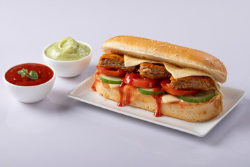Fresh submarine sandwiches with ham, cheese, bacon, tomatoes, lettuce, cucumbers and onions on White background.