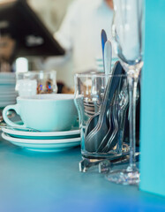 Empty glasses of various shapes and small teapots on the bar counter in restaurant or cafe. Details of the modern interior in the cafe.