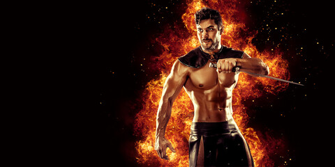 Sportive man in leather warrior costume with sword, fire on background