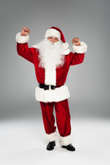 Excited santa claus showing yes gesture on grey background.