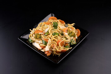 chinese food delivery black plate of yakisoba vegetarian black angle portrait
