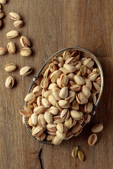 Salted pistachios on an old wooden table.
