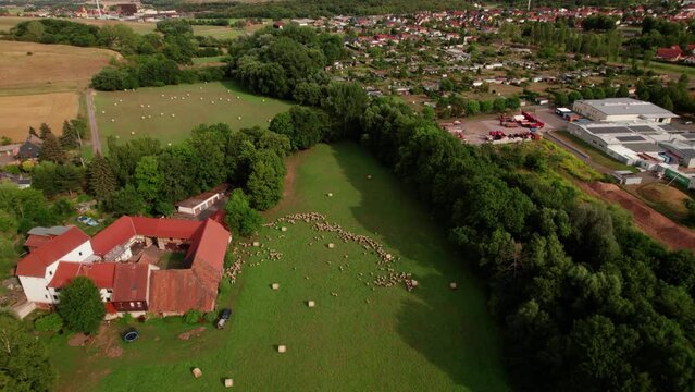Aer ial view of a German village surrounded by meadows, farmland and forest in Germany.