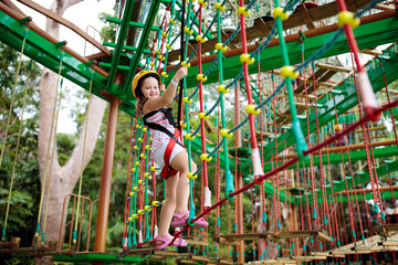 Obraz na płótnie Canvas Child in adventure park. Kids climbing rope trail.
