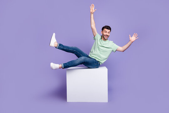 Full Length Photo Of Nice Young Guy Sit White Cube Copyspace Falling Back Wear Trendy Gray Clothes Isolated On Violet Color Background