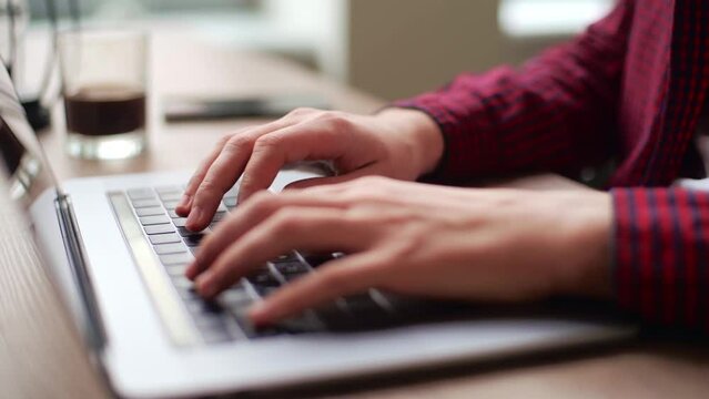 Close up of freelancer's developer hands typing program code on laptop keyboard in coworking. Businessman at work in working in office. Copywriter writing text on computer keyboard in coffeeshop.