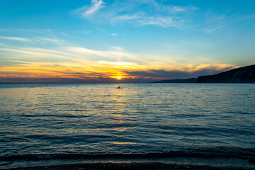 Beautiful sunset over the Black Sea. Bright colors appear on the horizon, while the waves beat against the shore.