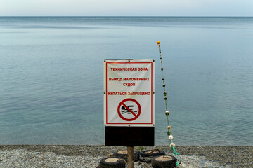 Signs installed on the beach state that swimming is prohibited, the exit of small vessels, a...