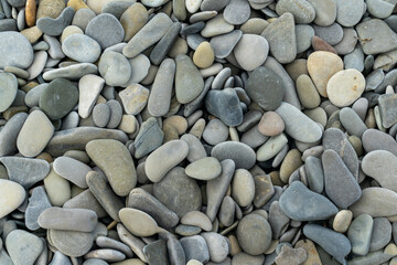 Smooth round pebbles texture background. Pebble sea beach close-up, dark wet pebble and gray dry pebble. High quality photo
