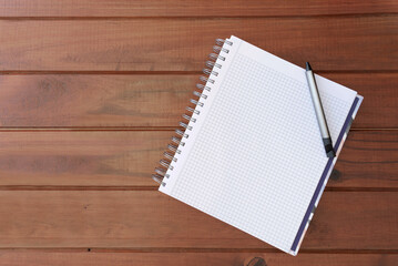 Notebook with square pages and pen on a wooden table