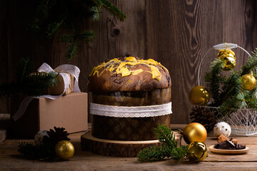 Traditional Italian Christmas Cake Panettone with white ribbon and festive decoration on wooden...