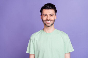 Fototapeta premium Portrait of friendly satisfied handsome man with brunet hairdo dressed t-shirt dental clinic ad isolated on purple color background