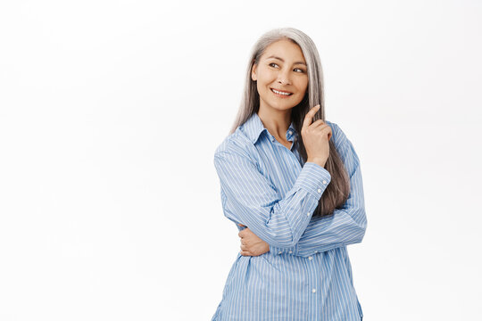 Beautiful Asian Lady, Senior Woman With Grey Hair, Good Facial Skin, Smiling And Looking Happy At Camera, Standing Over White Background