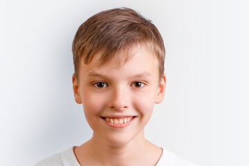 Close up portrait of a happy boy smiling on white background showing healthy teeth