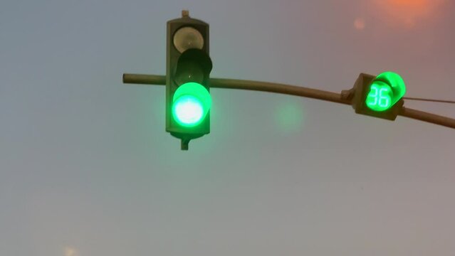 Green traffic signal turned on with a cloudy sky in the background
