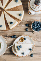 Cheesecake with blueberries on white plate. Classical New York cheesecake. Wooden background