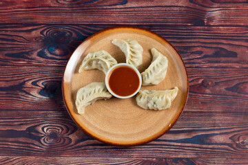 Steamed chicken mom wrap with ketchup served in a dish isolated on background top view