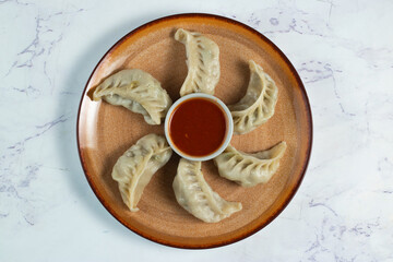 Steamed chicken mom wrap with ketchup served in a dish isolated on background top view