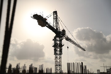 Large construction site including several cranes working on a complex, with cloudy background