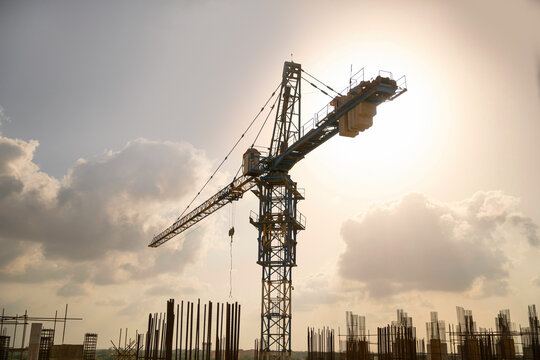 Large construction site including several cranes working on a complex, with cloudy background
