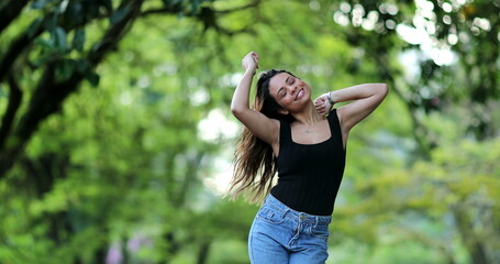 Happy woman dancing with joy outside, free mixed race girl dance, person jumping with joy