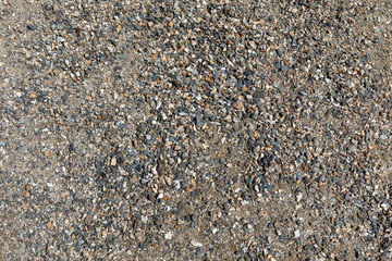 Smooth round pebbles texture background. Pebble sea beach close-up, dark wet pebble and gray dry...