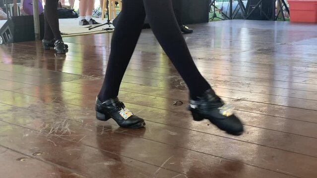 on St Patrick's Day a young girl doing an festive Irish stepdance on wood floor