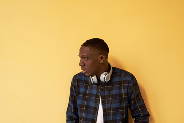 Man with headphones around neck looking away.