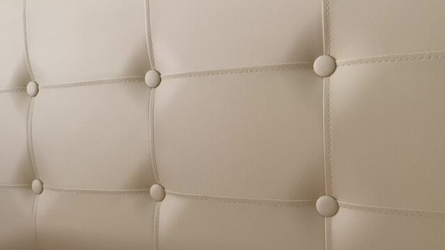 leather pattern upholstery wall with inset button tufting and folds 