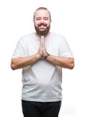 Young caucasian hipster man wearing casual t-shirt over isolated background praying with hands together asking for forgiveness smiling confident.