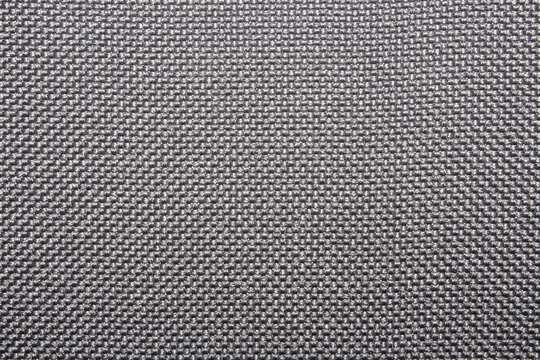 The texture of a dense gray carpet.The texture of gray woolen fabric.Grey braided background.