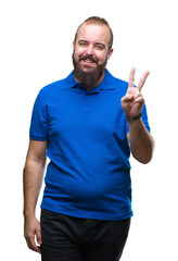 Young caucasian hipster man wearing blue shirt over isolated background smiling with happy face winking at the camera doing victory sign. Number two.