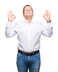 Fototapeta premium Middle age arab elegant man over isolated background relax and smiling with eyes closed doing meditation gesture with fingers. Yoga concept.