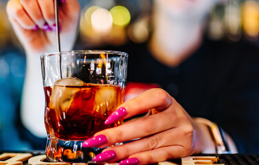 woman hand bartender making negroni cocktail in bar