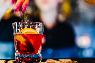 woman hand bartender making negroni cocktail in bar