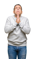 Middle age arab man wearing sport sweatshirt over isolated background begging and praying with hands together with hope expression on face very emotional and worried. Asking for forgiveness