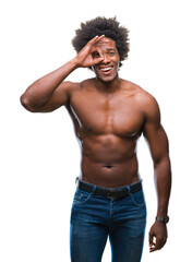 Fototapeta premium Afro american shirtless man showing nude body over isolated background doing ok gesture with hand smiling, eye looking through fingers with happy face.