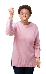 Beautiful young african american woman over isolated background angry and mad raising fist frustrated and furious while shouting with anger. Rage and aggressive concept.