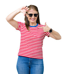 Middle age mature woman wearing sunglasses over isolated background smiling making frame with hands and fingers with happy face. Creativity and photography concept.