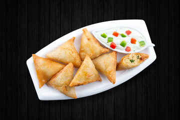Top view aloo and chicken samosas 
back wood background.