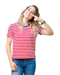 Beautiful young blonde woman over isolated background Pointing with hand finger to face and nose, smiling cheerful