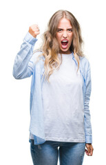 Fototapeta premium Beautiful young blonde woman over isolated background angry and mad raising fist frustrated and furious while shouting with anger. Rage and aggressive concept.
