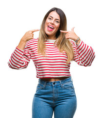 Obraz na płótnie Canvas Young beautiful woman casual stripes winter sweater over isolated background smiling confident showing and pointing with fingers teeth and mouth. Health concept.
