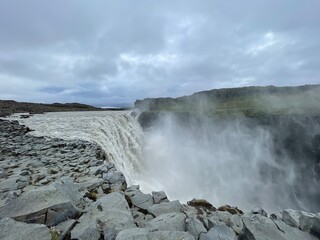 Dettifoss Island (Europa) Isländischer Wasserfall in der Natur mit Wiese, Moos, Blauem Wasser, Felsen, Basaltsäulen, Schlucht
