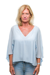 Middle age blonde business woman over isolated background skeptic and nervous, frowning upset...
